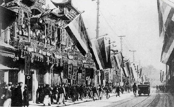 Nanjing Road in Shanghai after the Shanghai Uprising, hung with the 'Five Races Under One Union' flags used by revolutionaries in Shanghai and Northern China. (Wikimedia Commons)